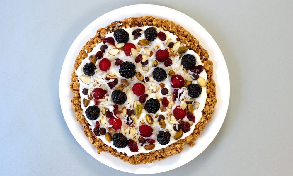 Healthy Breakfast Pizza With Granola Crust – A healthy and delicious recipe that’s easy to make with a few simple ingredients: granola, peanut butter, almonds, cinnamon, yogurt, berries and nuts. A perfect, vegetarian breakfast or brunch idea. So yummy! Video recipe. | tipbuzz.com