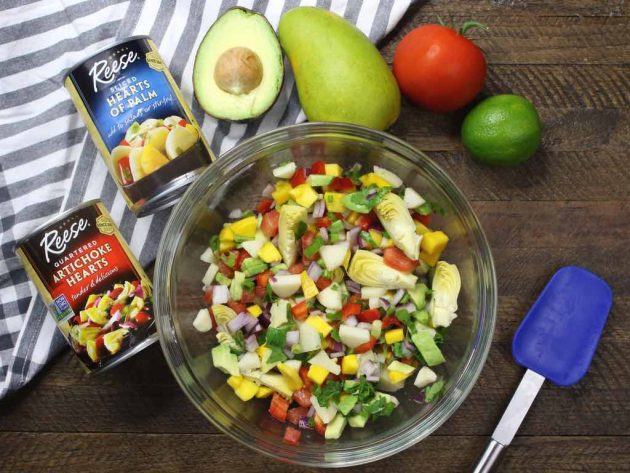 This photo shows a bowl of beautiful vegan ceviche filling made with hearts of palm, artichoke hearts, mango, avocado, red onion and lime juice as ingredients