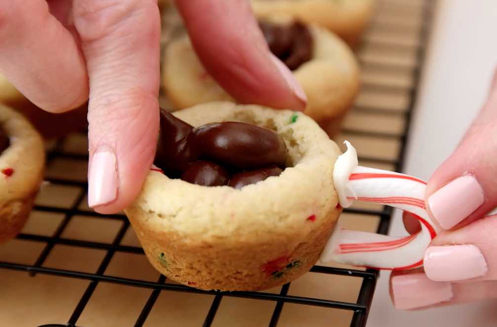 Attaching candy cane handles onto hot chocolate cookie cups