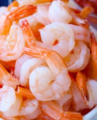 Medium-size, peeled, tail-on shrimp in a bowl after boiling with a beautiful orange-pink color