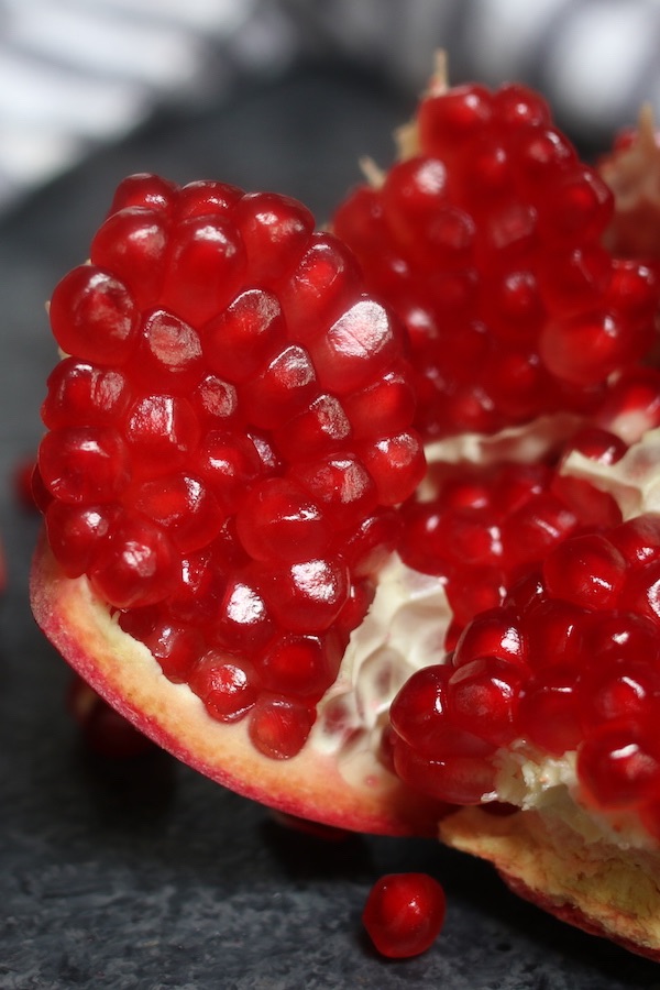 Close-up of a ripe pomegranate section after being cut open and showing beautiful red arils 