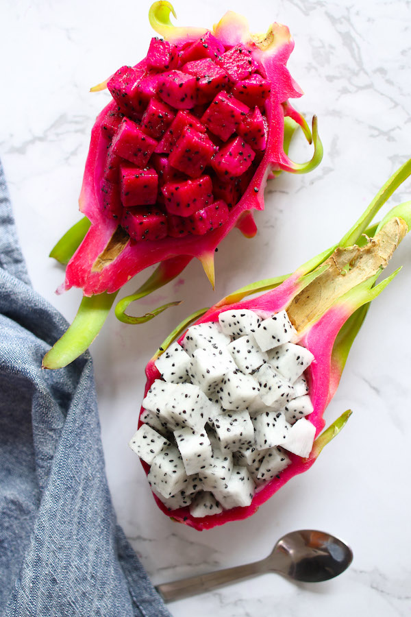 How to Eat Dragon Fruit by serving it cubed in its own skin; this photos shows two varieties, both white flesh and purple flesh for an attractive color contrast