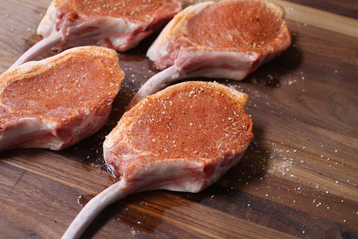 Bone-in pork chops that have been rubbed with seasonings before cooking