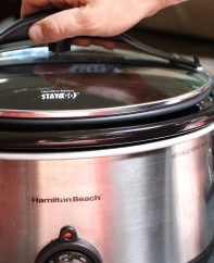 Placing the sealing lid onto a slow cooker