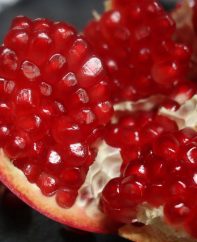 Closeup of a pomegranate that has been cut open to expose the juicy red arils inside