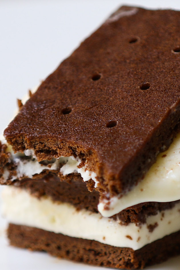 A stack of chocolate ice cream sandwiches with a bite taken from the top one