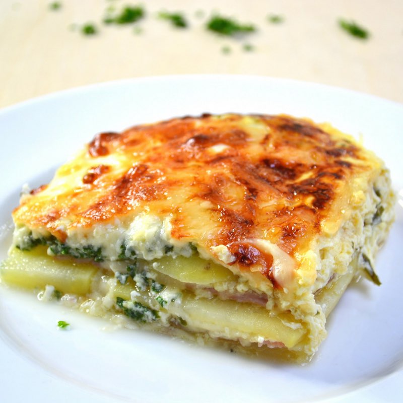 Layered ham and potato casserole on a serving plate