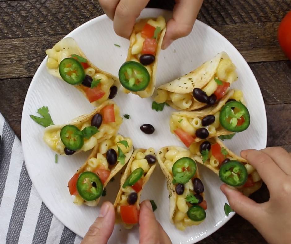 Picking up mini tacos from a serving plate