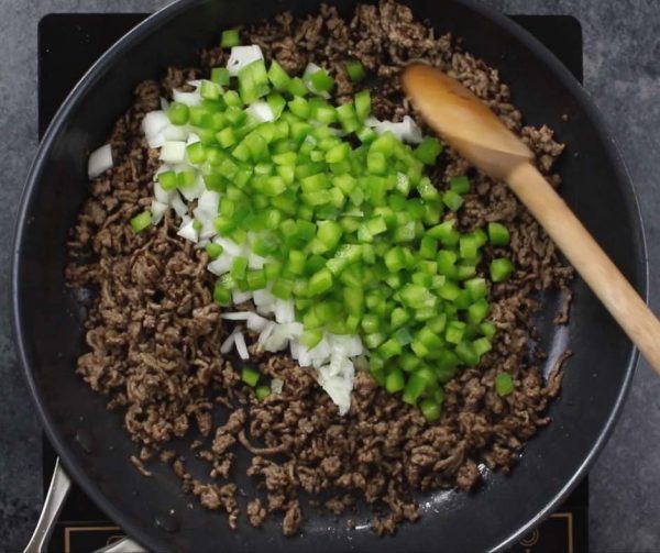 This photo shows frying beef with onions and green peppers to make Philly Cheesesteak