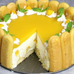 No Bake Mango Cheesecake – the most beautiful and unbelievably delicious charlotte-style mango cheesecake. All you need is some simple ingredients: mango juice, ladyfingers, cream cheese, sugar, whipped cream, mango, gelatin, and rum or triple sec. So Good! Perfect for a holiday party or a special occasion such as birthday and Mother’s Day! No bake cheesecake. Dessert recipe. Vegetarian. Video Recipe | Tipbuzz.com