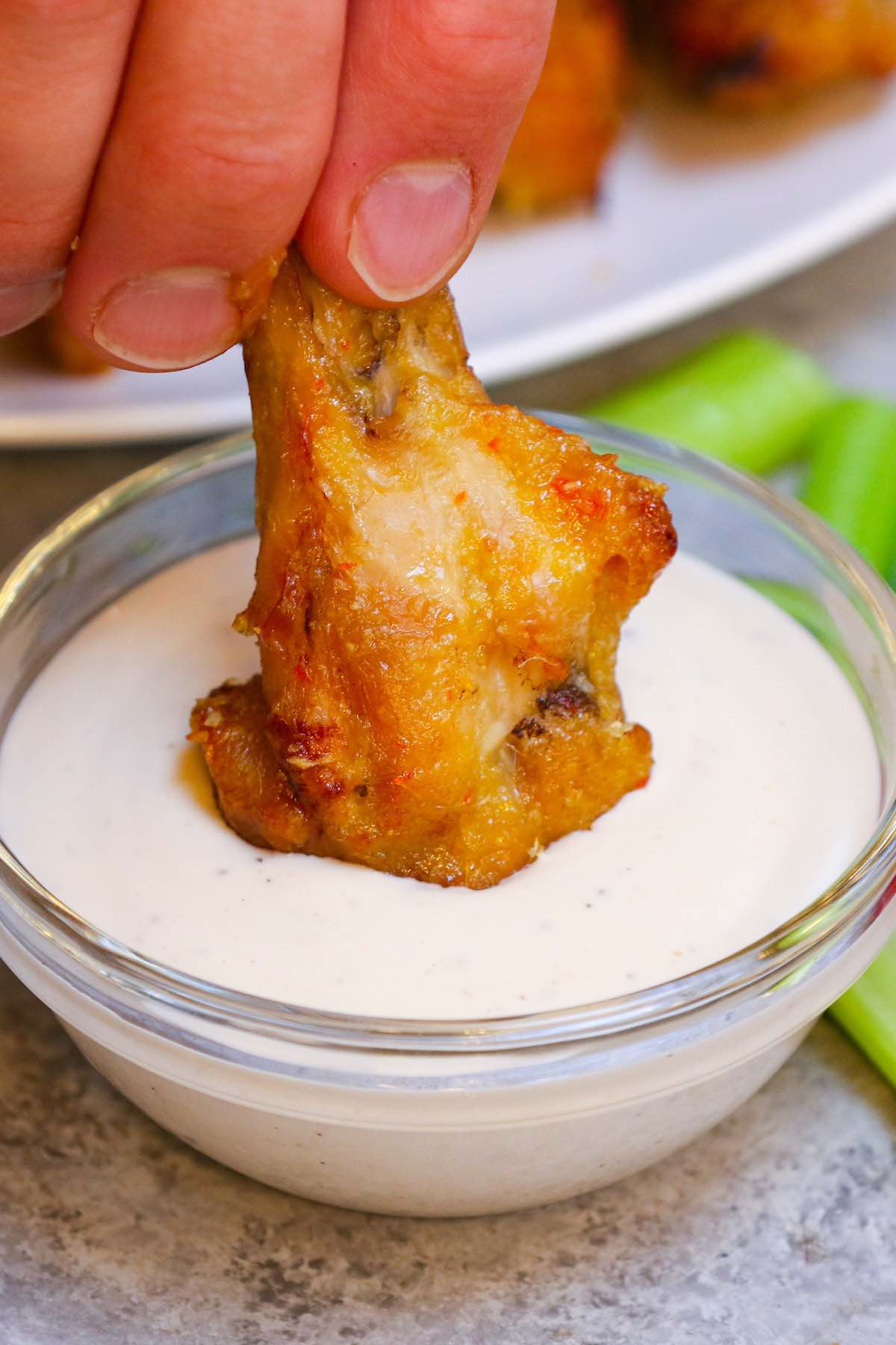 Dipping a mango habanero chicken wing in ranch sauce.