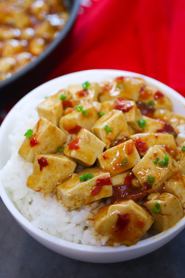 A serving of mapo tofu on a plate on a bed of steamed rice