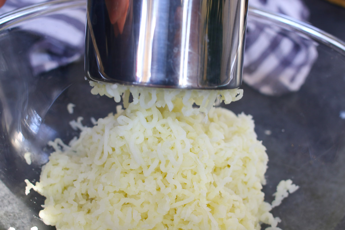 Using a ricer to mash microwaved potatoes for the a fluffy and creamy texture