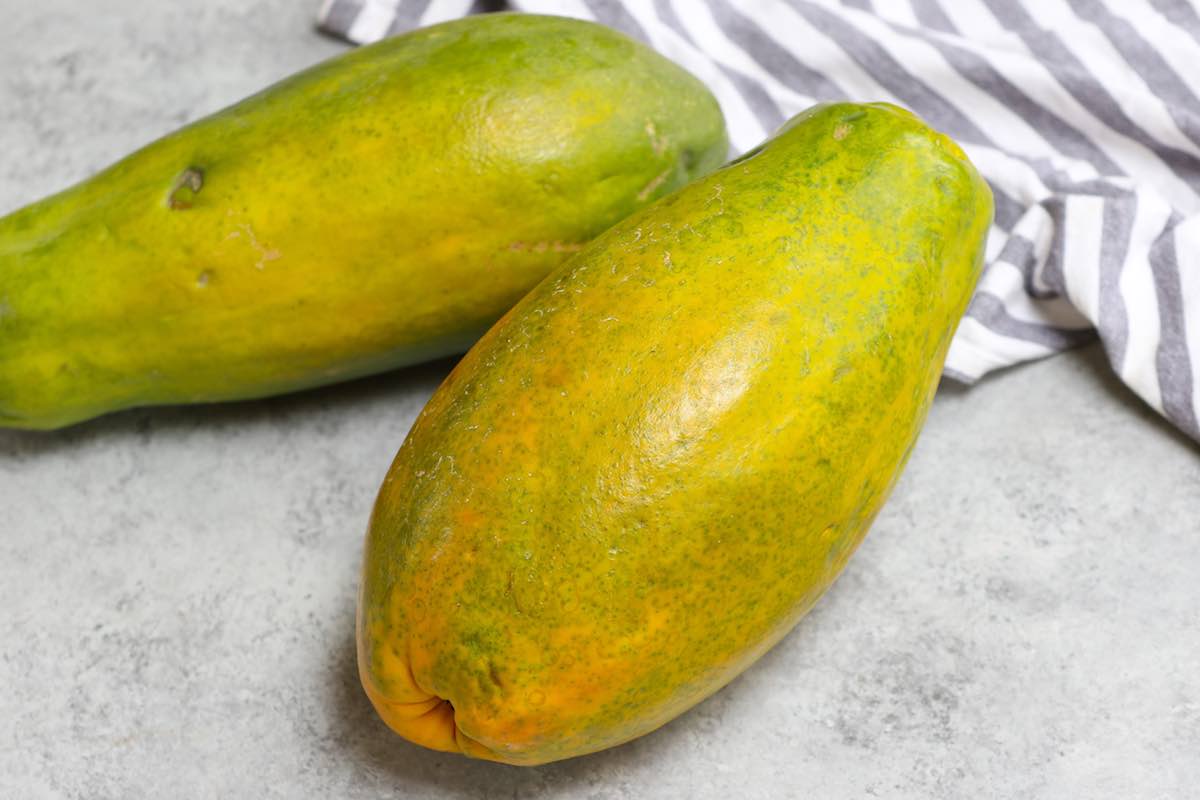 Ripe large papaya with skin turning from green to yellow and a few inconsequential blemishes