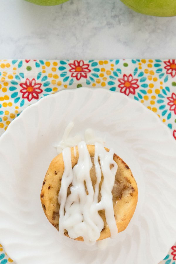 Cinnamon Roll Apple Pie Cups - this photo shows a mini apple pie made with cinnamon roll dough and served with icing on top