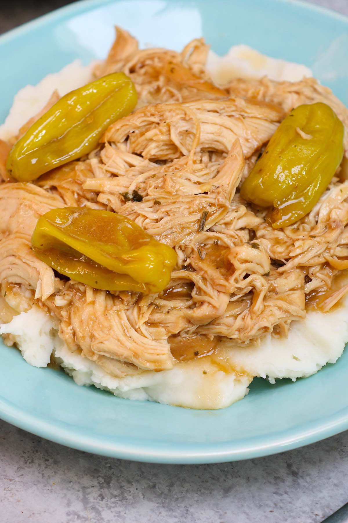 Mississippi chicken served on a bed of mashed potatoes