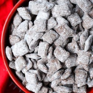 Muddy buddies in a serving bowl on a table - this delicious snack is made with Chex cereal and is also called Puppy Chow