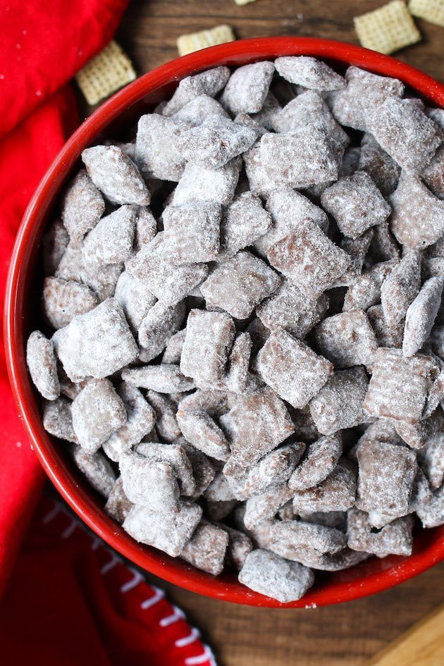 Muddy buddies in a serving bowl on a table - this delicious snack is made with Chex cereal and is also called Puppy Chow