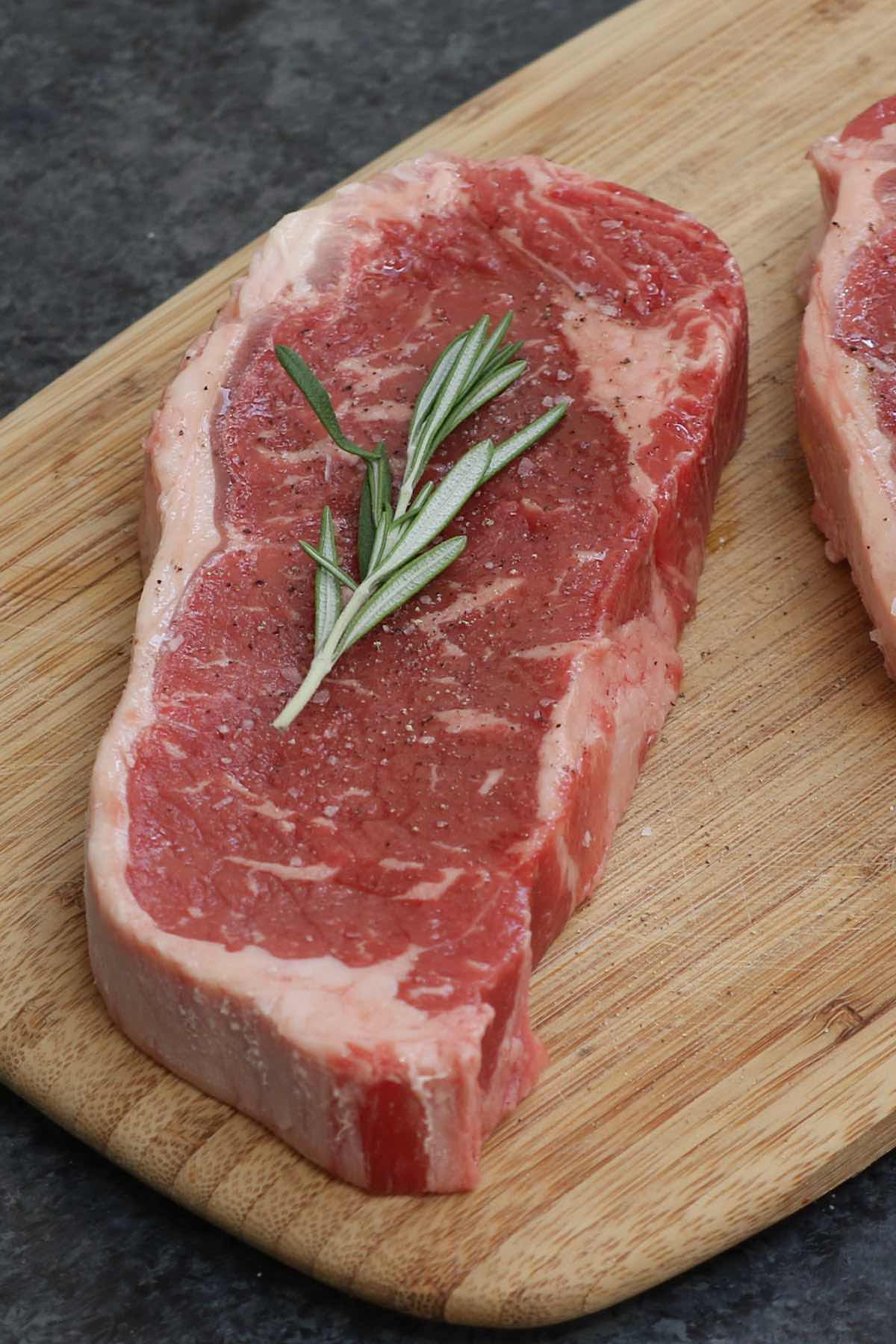 A raw striploin showing its oblong shape and the ribbon of fat along the outside