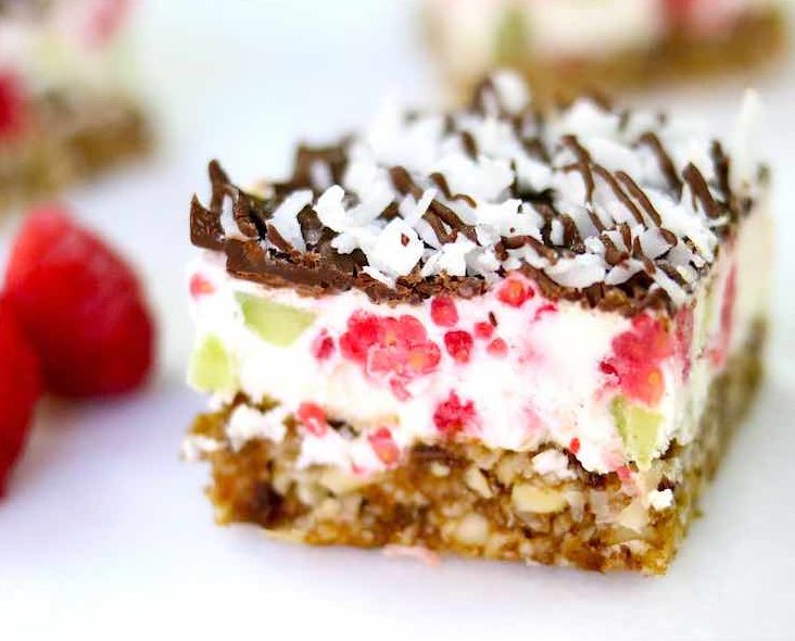 Closeup of a raspberry coconut bar made with almonds, dates, raspberries, melted chocolate and coconut