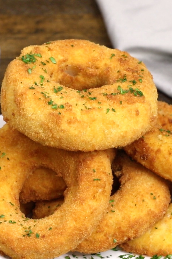 A stack of mac and cheese onion rings on a serving plate