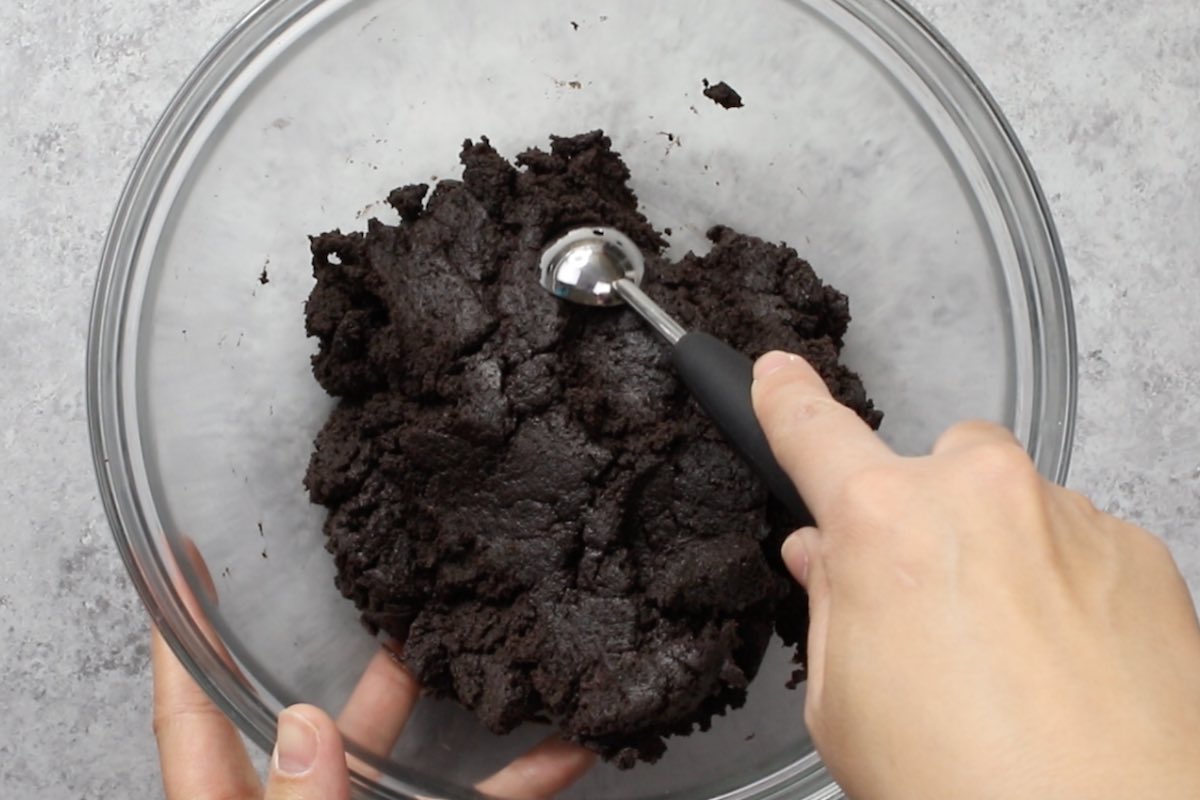 Scooping out oreo cheesecake using a melon baller