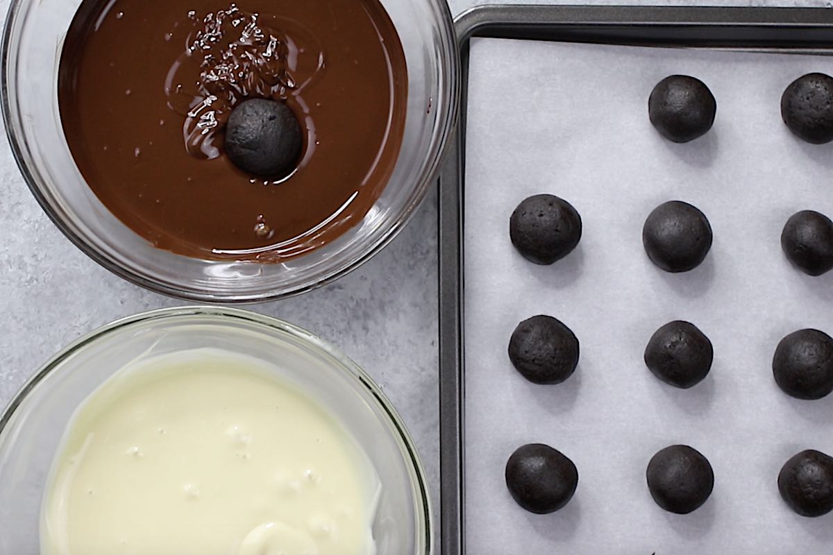 How to dip oreo balls in melted chocolate, with bowls of semisweet and white chocolate to make different color coatings