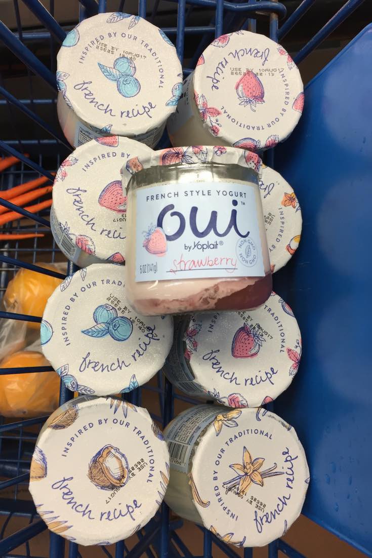 This photo shows a variety of Oui By Yoplait French-style yogurt pots in a shopping cart at Walmart