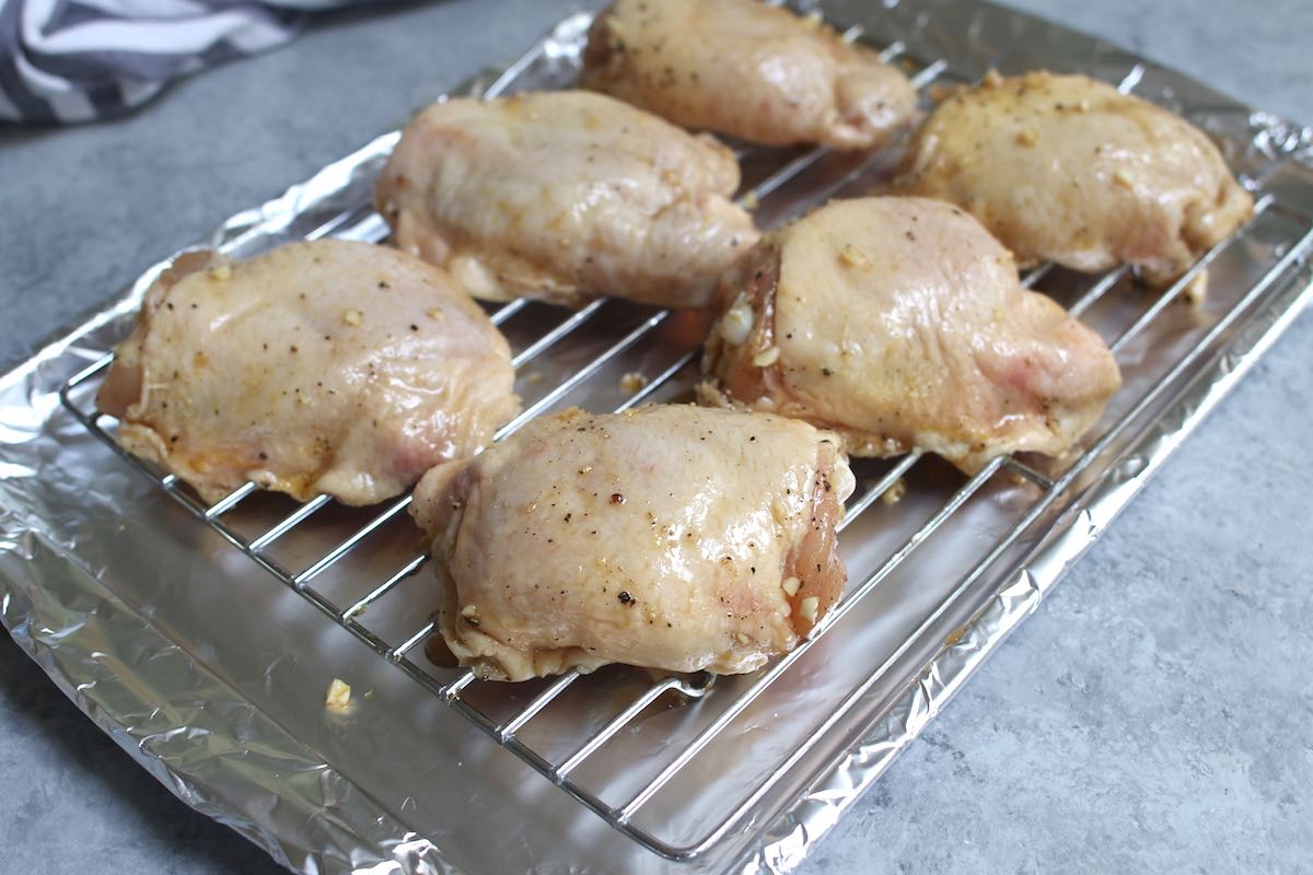 Place marinated chicken thighs on the rack with the skin side up