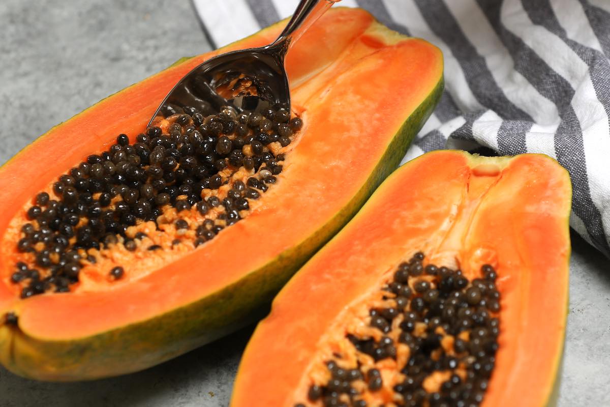 Cut papaya showing the orange flesh and dark seeds