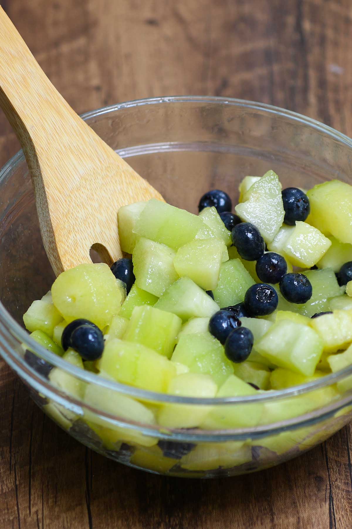 Mixing pepino melon with blueberries and lime juice for a refreshing fruit salad