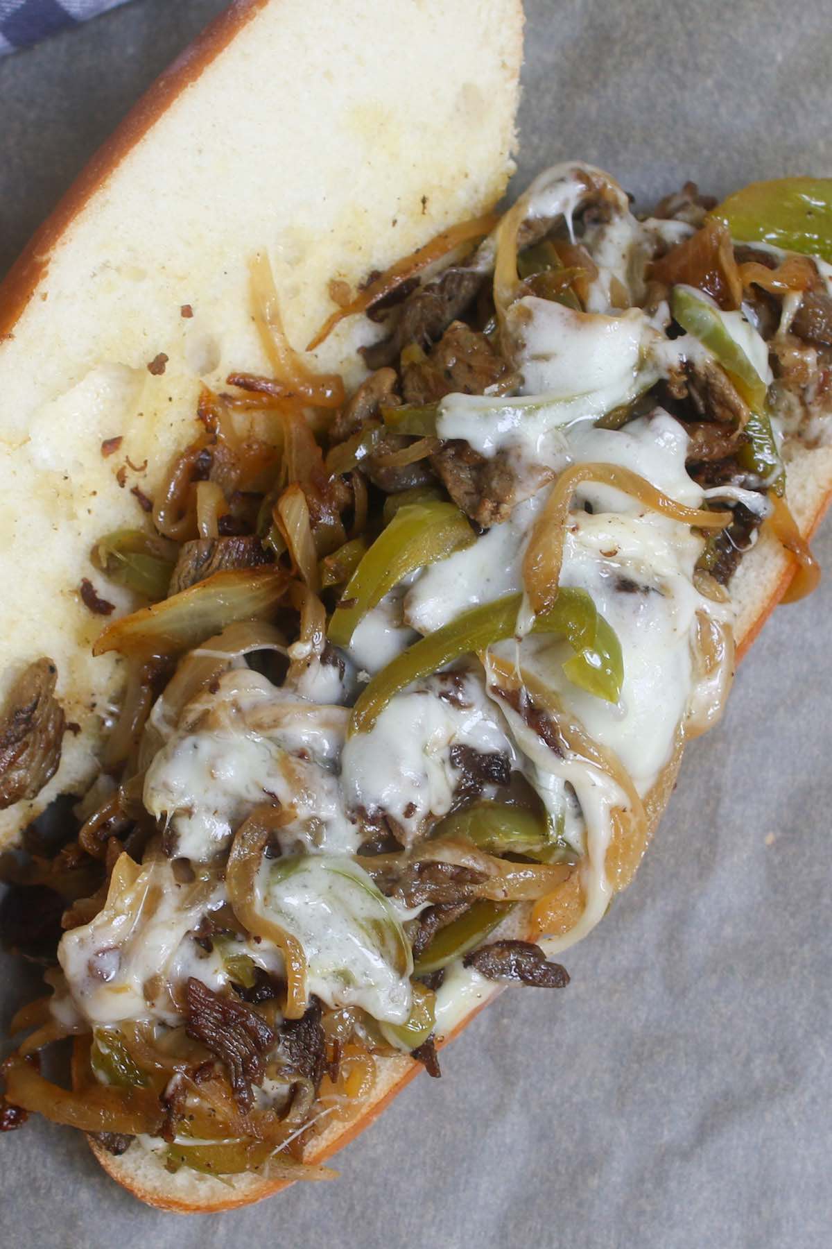 Philly cheesesteak recipe is made with thinly sliced rib-eye beef and sautéed onions, topped with ooey, gooey, melted provolone or Cheez Whiz, and served on a soft yet crusty hoagie roll!