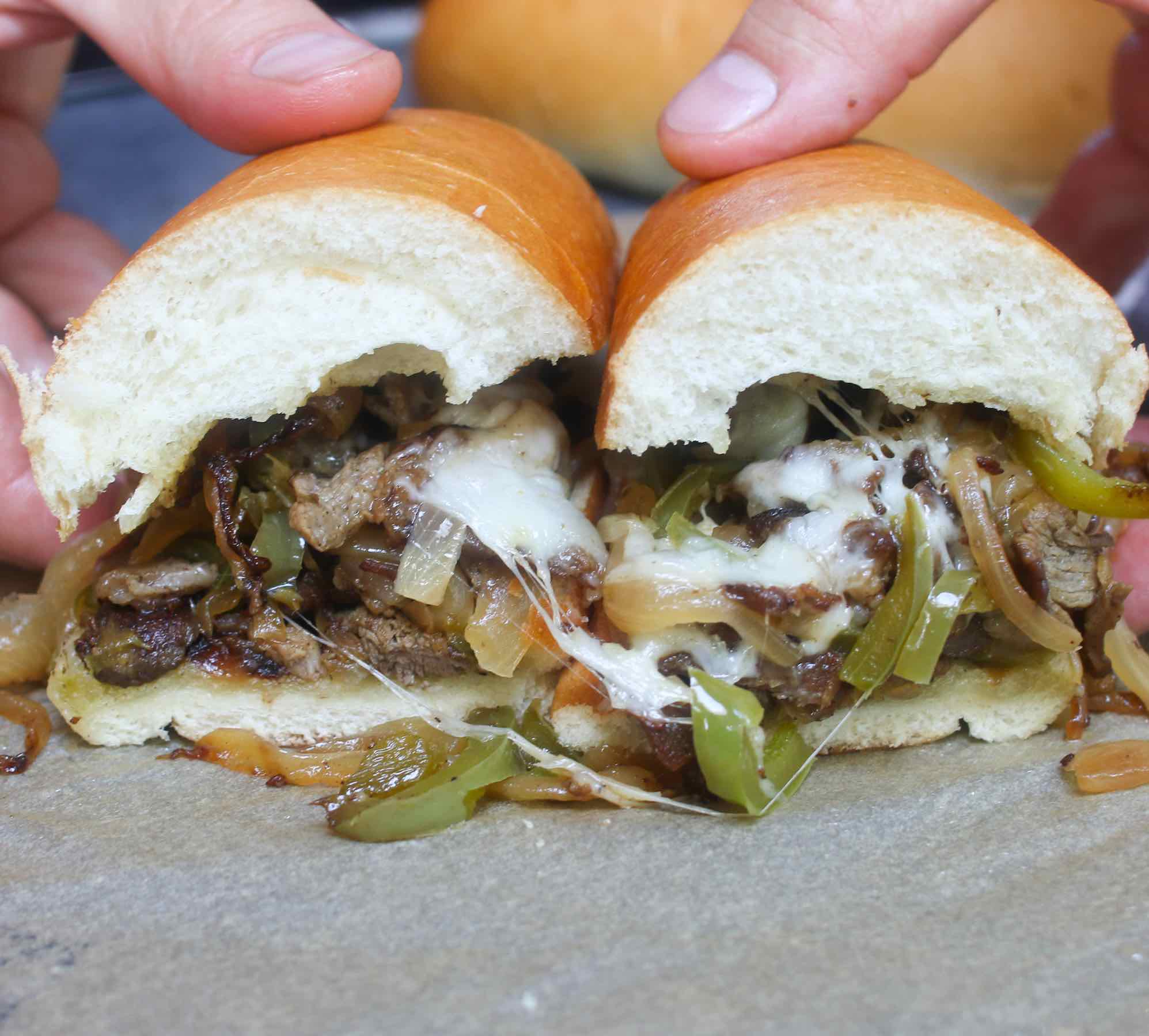 Philly cheesesteak recipe is made with thinly sliced rib-eye beef and sautéed onions, topped with ooey, gooey, melted provolone or Cheez Whiz, and served on a soft yet crusty hoagie roll!