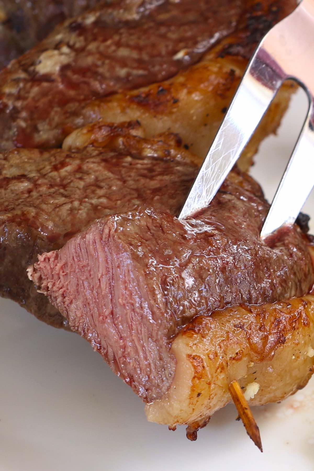 Closeup of Brazilian steak cooked medium and carved into pieces