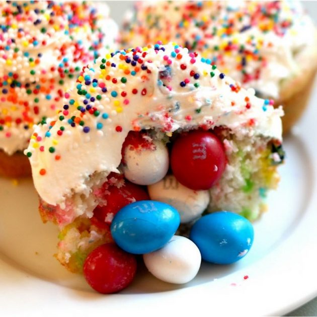 Closeup of Piñata Cupcakes showing M&Ms inside with frosting and sprinkles on top