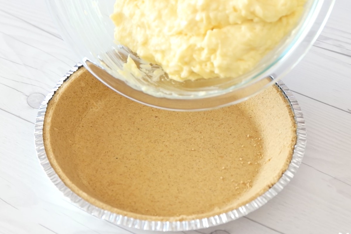 Adding the filling to the graham cracker pie crust.