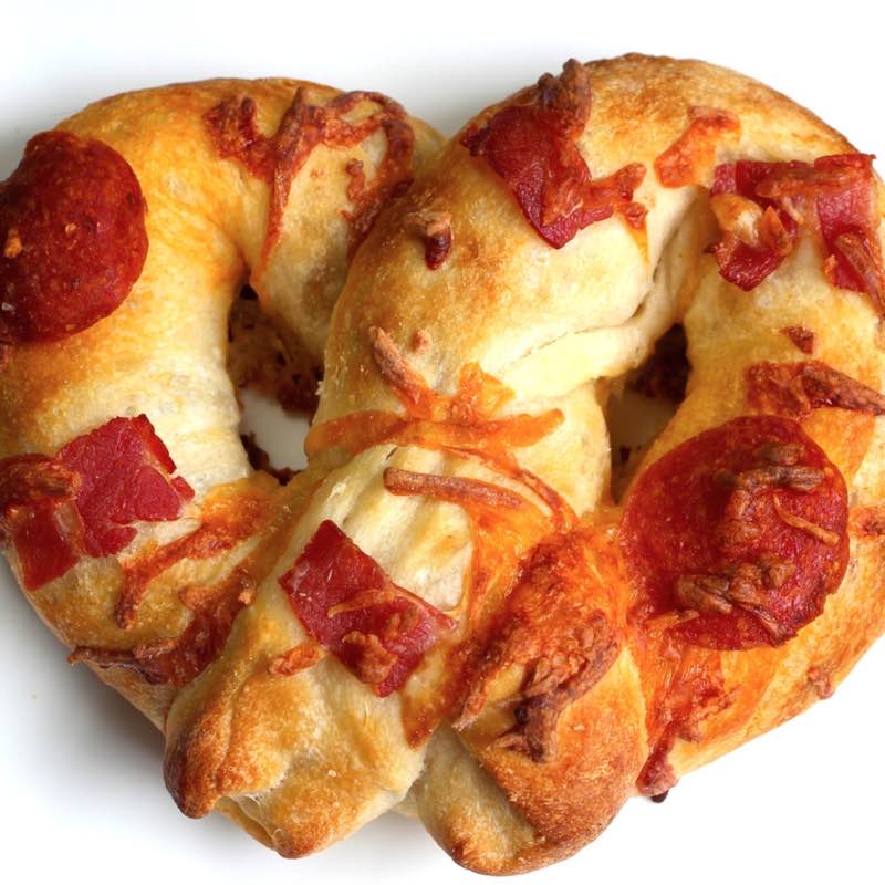 Homemade pizza pretzel with pepperoni, sausage and bacon