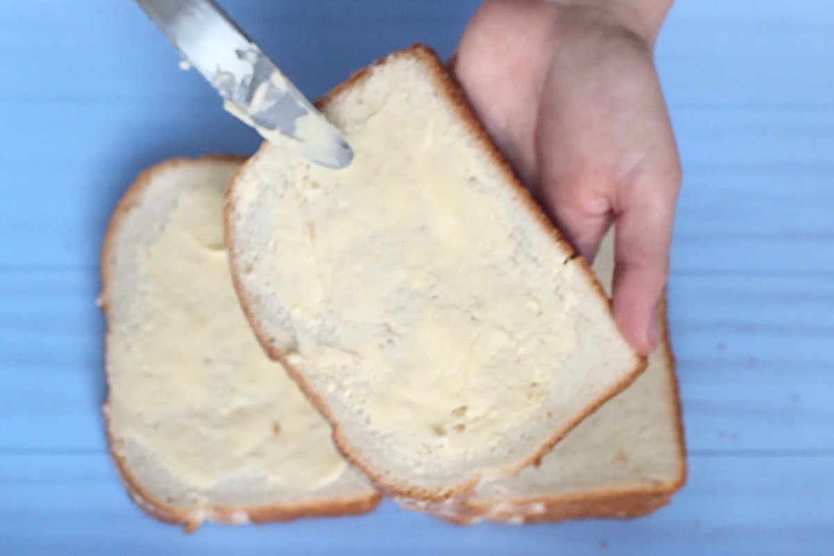 Close-up of buttering the bread.