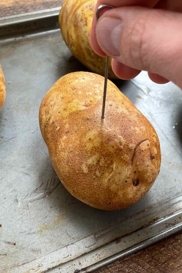 Poking holes in a russet potato so that moisture can escape during baking 