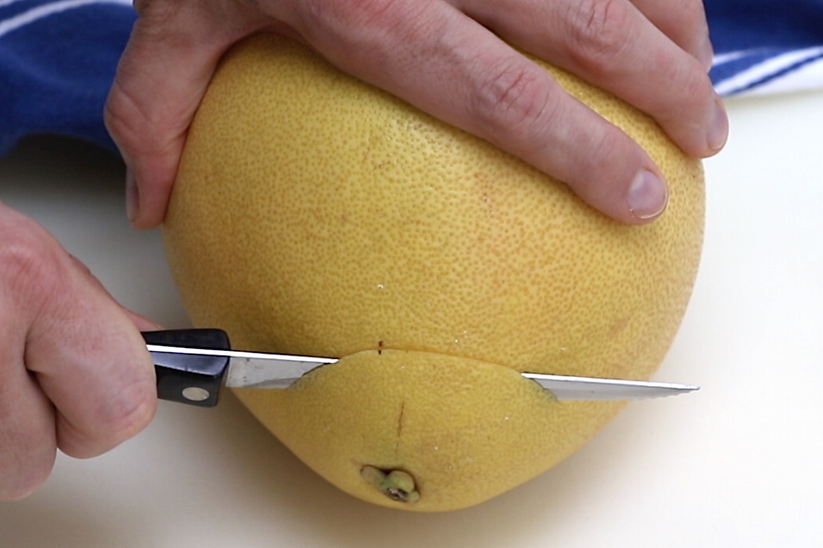 Slicing an inch off the top of the pomelo.