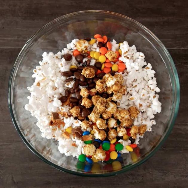 Mixing popcorn and candy together in mixing bowl when making Popcorn Cake