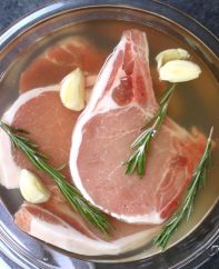 This easy pork chop brine recipe is made with salt, brown sugar, apple cider vinegar, rosemary, garlic, and water. It guarantees tender and juicy meat every time! The brined pork chops are perfect for grilling, pan frying, or baking.
