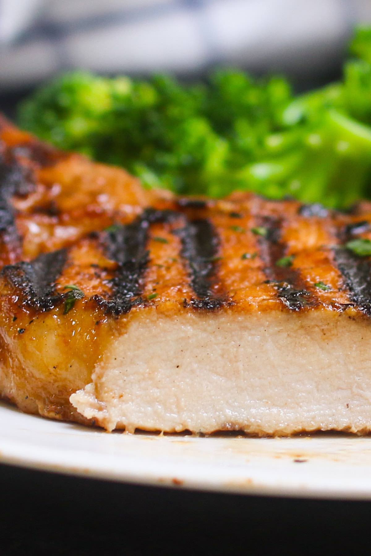 Closeup of marinated pork chops grilled to perfection so the outside is fully seared and the inside is tender and juicy