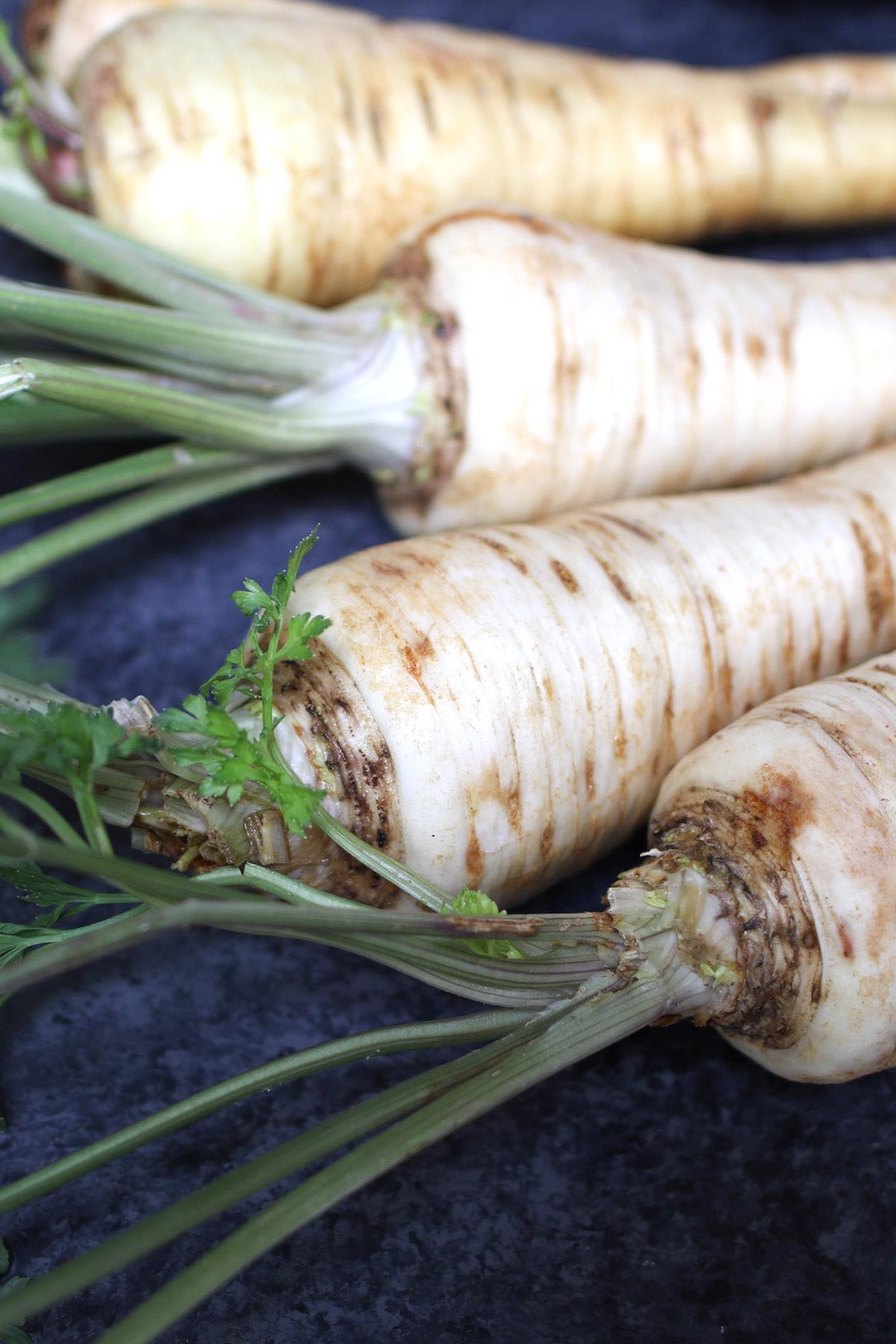 Fresh raw parsnips with white skin and intact tops