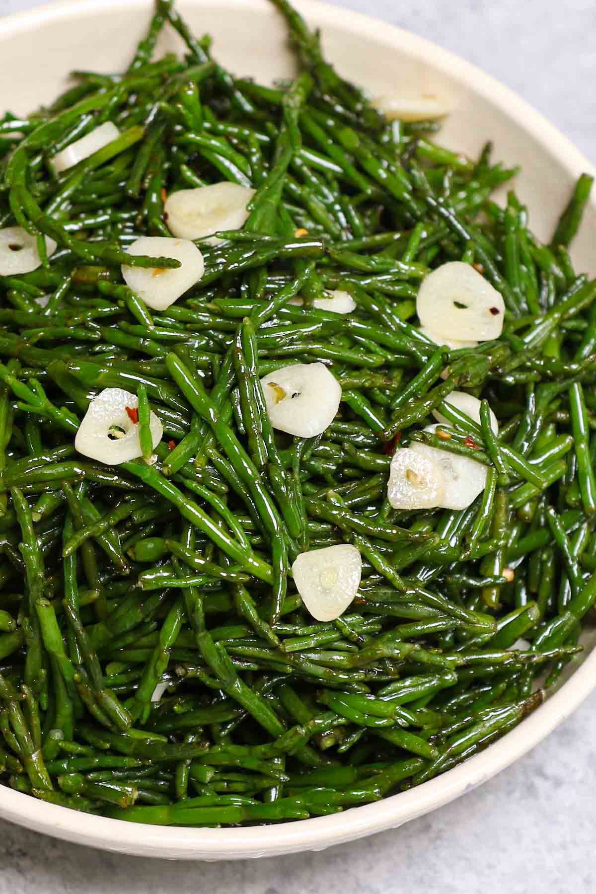 A serving platter full of samphire cooked with garlic