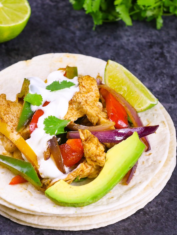 Fajitas served with avocado, fresh lime and sour cream