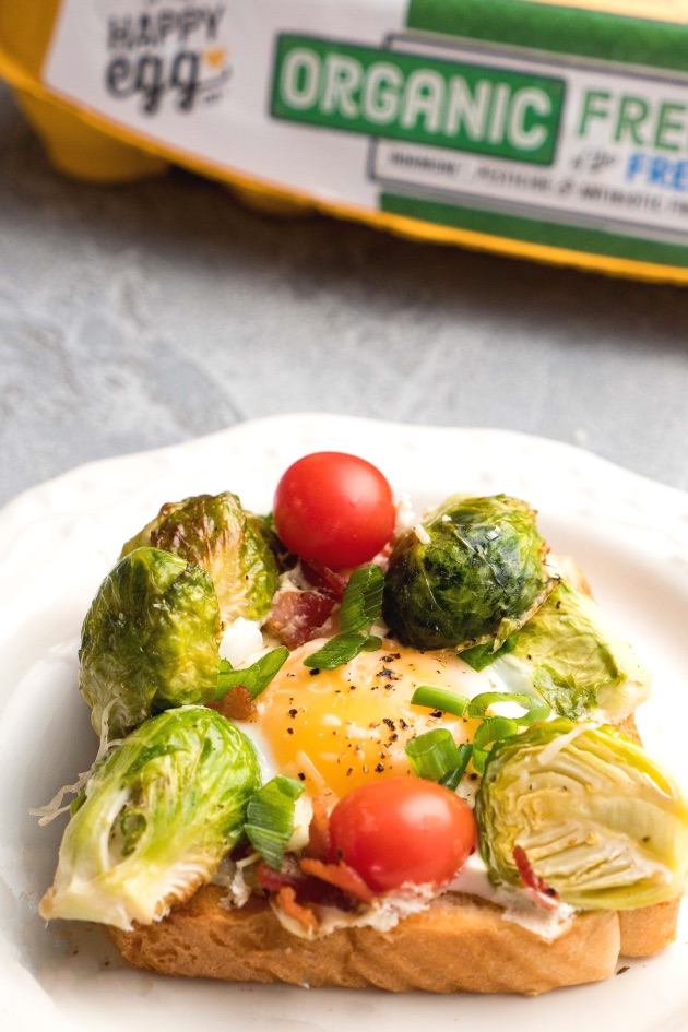 These sheet pan eggs are combined with Brussel sprouts and bacon before being served on toast for an elegant breakfast or brunch idea