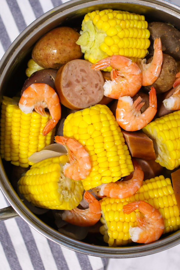 Shrimp boil in a pot after boiling with potatoes, corn on the cob, smoked sausage and onion