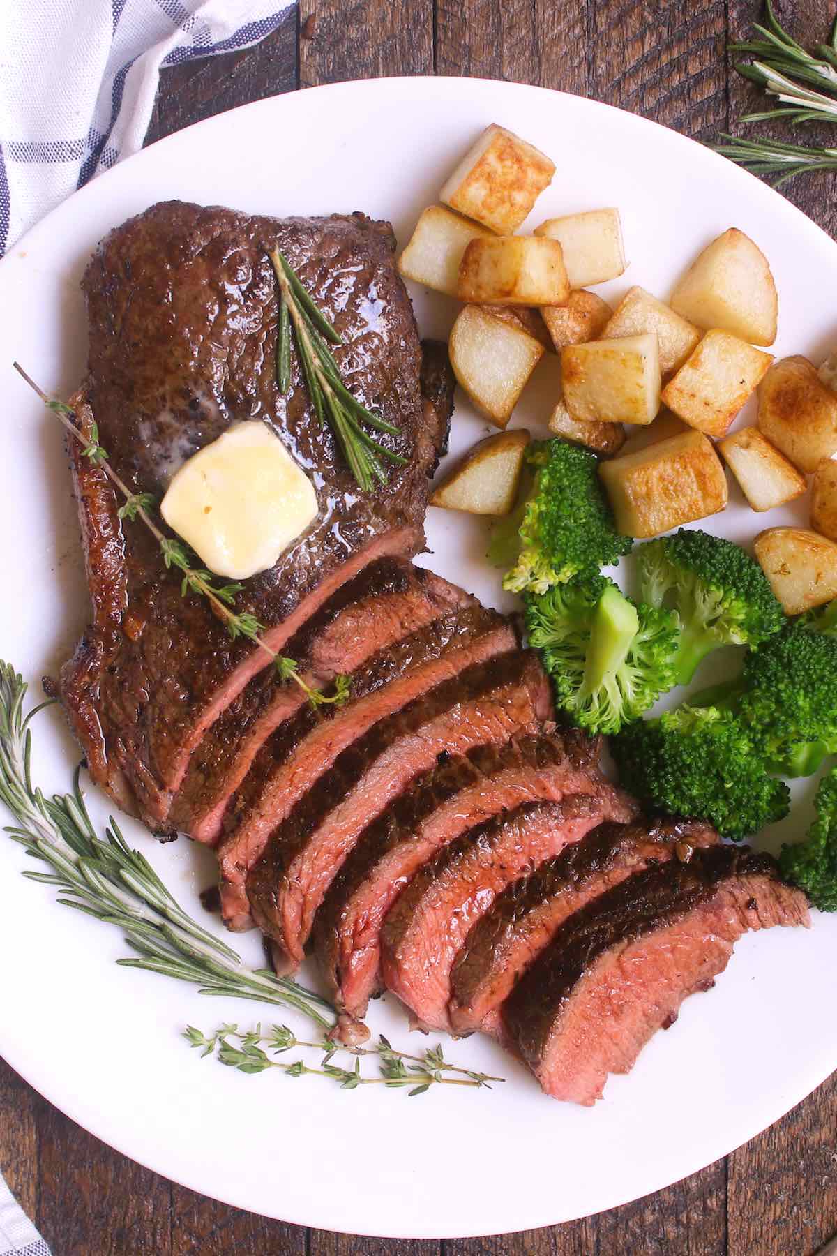 Steak dinner with sauteed potatoes, broccoli and a pat of butter