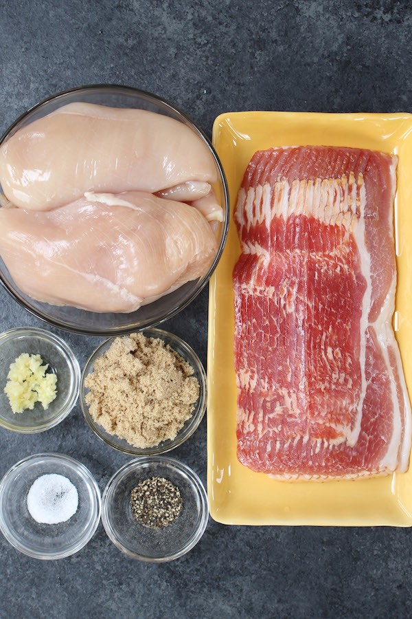 Ingredients for slow cooker chicken breast recipe: boneless skinless chicken breasts, bacon, brown sugar and minced garlic with optional salt and pepper